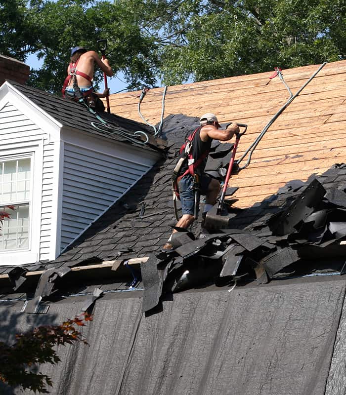 Roofers replacing a black shingle roof